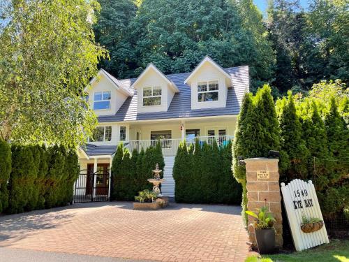 a white house with a sign in front of it at Kye Bay BnB - A Place to Breathe in Comox