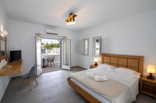 sypialnia z łóżkiem, biurkiem i telewizorem w obiekcie Petra Aqua Villa w mieście Perissa