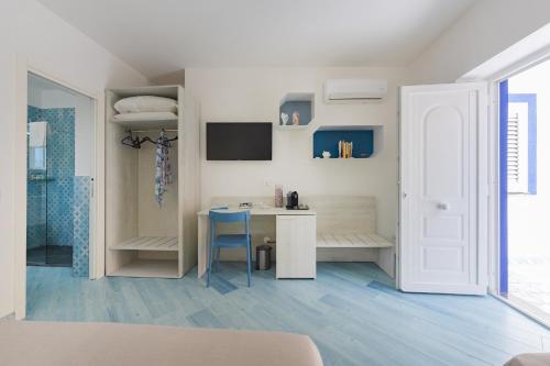 a white room with a desk and a table at Poseidonia Rooms in Procida