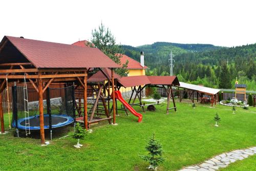 un parque con parque infantil con tobogán en Casa Maria Izvorul Muresului, en Izvoru Mureşului