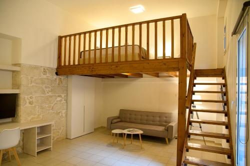 salon z łóżkiem na podwyższeniu i kanapą w obiekcie Uni Island - City Center Suites w Heraklionie