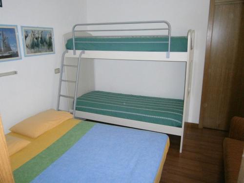 カオルレにあるMarconi Bilocale - Agenzia Cocalの二段ベッドが備わるドミトリールームのベッド1台分です。