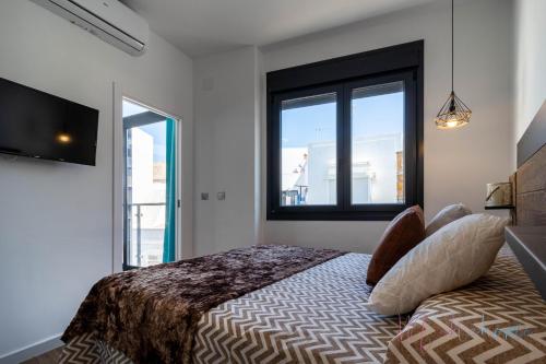Apartamentos Luxury Doña Bella 1d tesisinde bir odada yatak veya yataklar