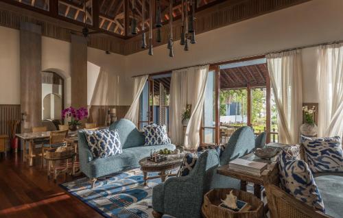 a living room with blue couches and tables at Four Seasons Resort Langkawi in Tanjung Rhu