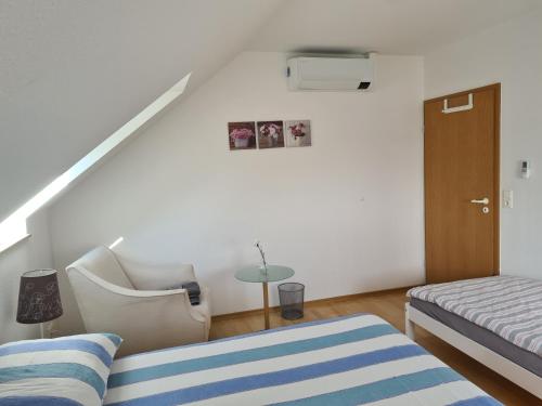 een slaapkamer met een bed, een stoel en een trap bij Zimmer Paradiso in Busingen am Hochrhein