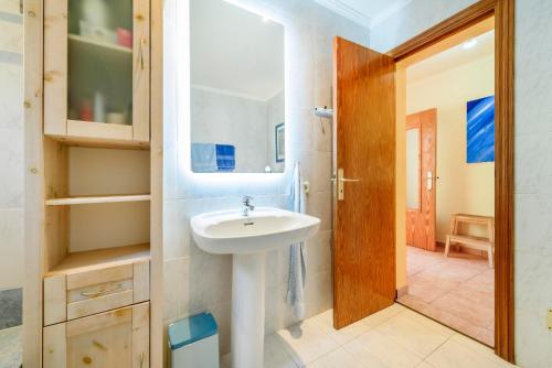 une salle de bain avec un lavabo et un miroir dans l'établissement Casa Folara, à Cala Llombards
