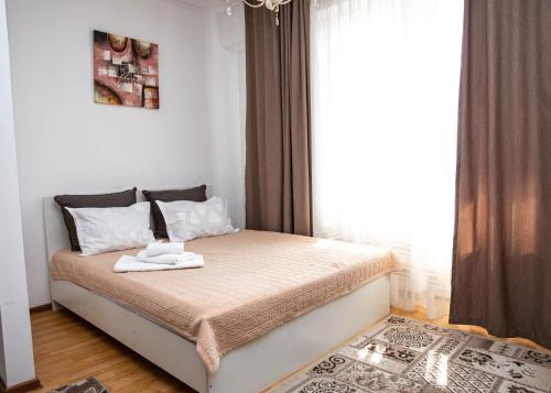 a bedroom with a bed with a towel on it at Aparthotel Almarent in Almaty