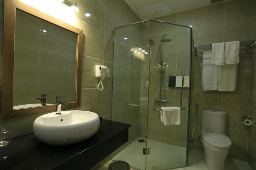 a bathroom with a sink and a glass shower at Phung Hung Boutique Hotel in Phu Quoc