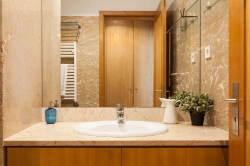 a bathroom with a sink and a mirror at The Refreshing Seaside Home in Matosinhos