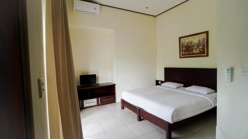 a bedroom with a bed and a television in it at The Janan Villa in Sanur