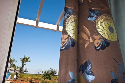 a window with a curtain with butterflies on it at Masseria Stellato in Nardò