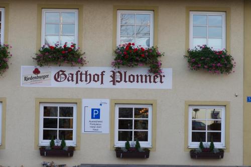 a building with flowers on the side of it at Il Plonner - Hotel Restaurant Biergarten in Weßling