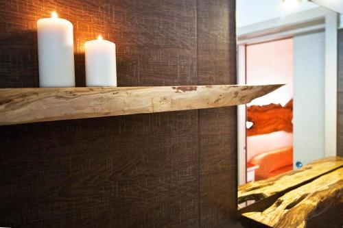 a shelf with two candles on a wall at Masseria Stellato in Nardò