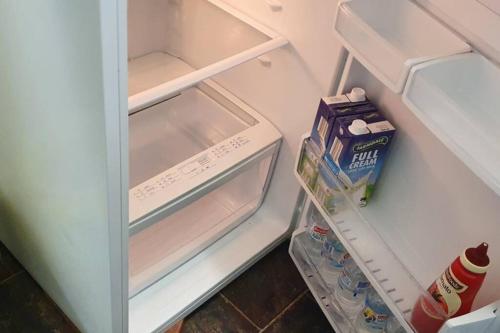 an open refrigerator with milk and a box of milk at Golden Mount Rest Townside in Mount Morgan