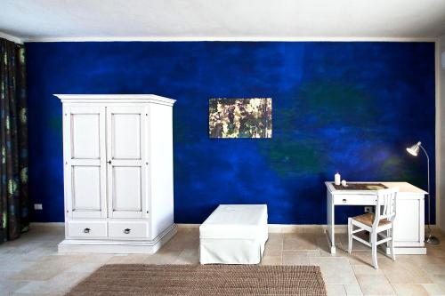 a blue wall with a white cabinet and a desk at Masseria Stellato in Nardò