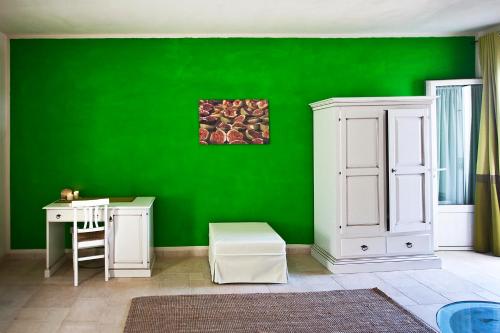a green wall in a room with a desk and a table at Masseria Stellato in Nardò
