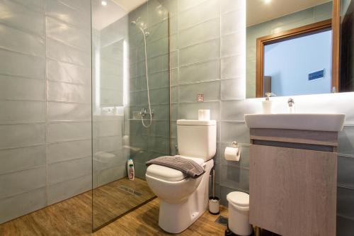 a bathroom with a toilet and a sink and a shower at Leone Suites in Thessaloniki