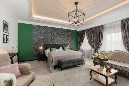 Habitación de hotel con cama y pared verde en Andrássy Kúria & Spa, en Tarcal