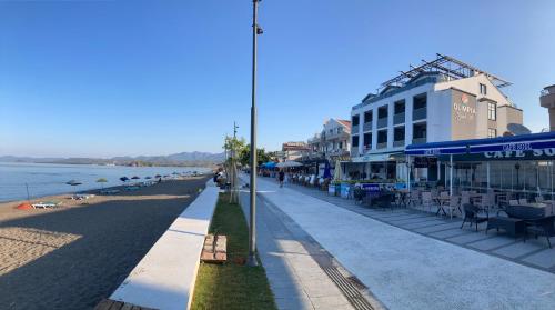 a street next to a beach with a building at Olimpia Hotel in Fethiye