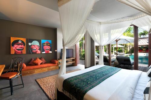 1 dormitorio con cama, sofá y piscina en Villa Abakoi, en Seminyak