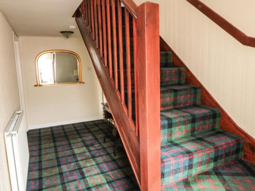 a set of stairs in a home with a plaid carpet at Stable Lodge in Coldstream