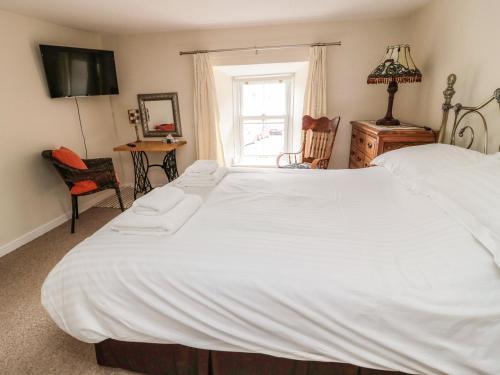 a large white bed in a room with a window at Stable Lodge in Coldstream