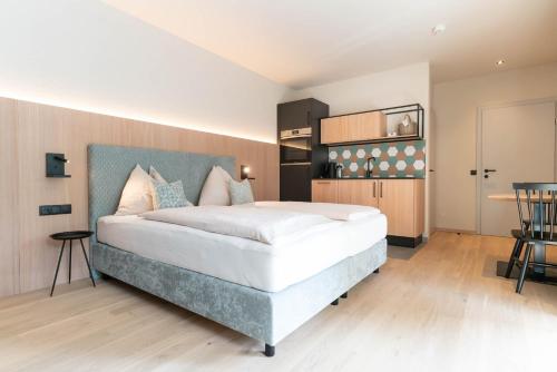a bedroom with a large bed and a table at Apart & Suiten Hotel WEIDEN in Schladming