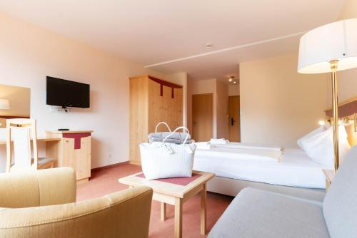 a hotel room with a large bed and a couch at Apart & Suiten Hotel WEIDEN in Schladming
