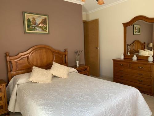 LouroにあるCasa Louromarのベッドルーム1室(ベッド1台、木製ヘッドボード、鏡付)