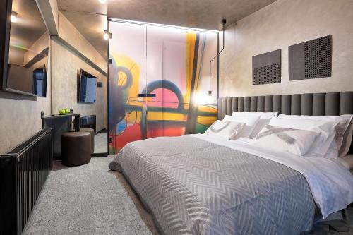 a bedroom with a large bed with a painting on the wall at Court 5 in Zagreb