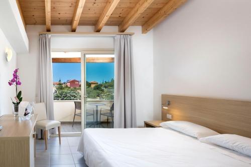 a bedroom with a bed and a view of a patio at Hotel San Teodoro in San Teodoro