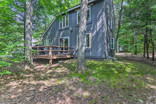 una cabaña gris en el bosque con árboles en 6 Mi to Lake Harmony Quiet Getaway with Deck!, en Lake Harmony