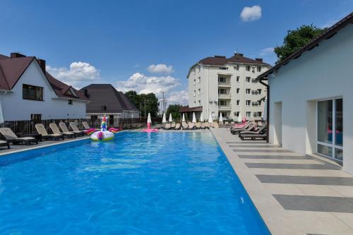 a large swimming pool with chairs and a hotel at Makis Hotel SPA in Lutsk