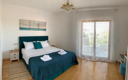 a bedroom with a large bed with towels on it at Pine Tree Villa in Pakoštane