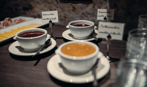 a table with two cups of coffee on plates at Hotel Plan Murin in La Valle