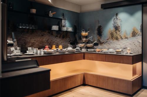 a restaurant with a counter with food on it at Hotel Plan Murin in La Valle