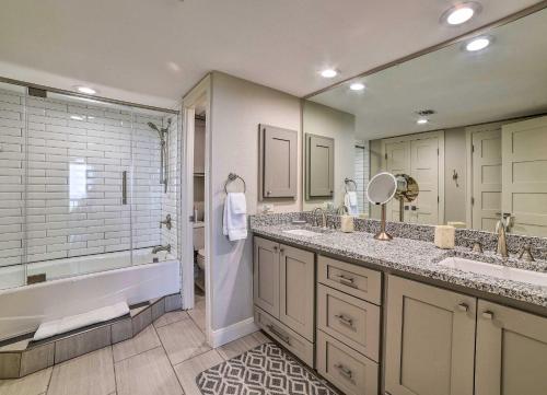 a bathroom with two sinks and a tub and a shower at Waterfront Port Aransas Condo with Beach Access! in Port Aransas