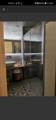 a bathroom with a shower and a sink and a mirror at Nenetta Rooms & Suites Monopoli in Monopoli