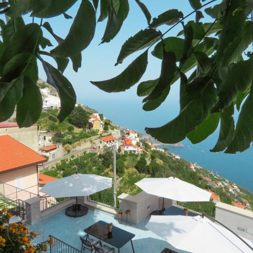 a view of a pool with umbrellas and the ocean at Lena Magda B&B in Furore