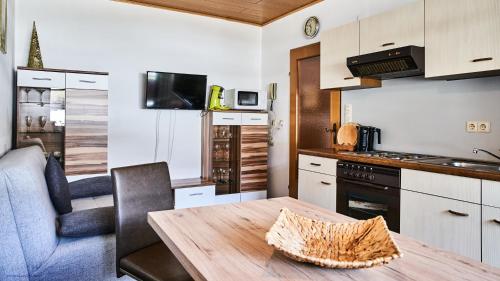 a small kitchen with a wooden table and a dining room at Ferienwohnung Bergerlebnis Ötscher in Lackenhof