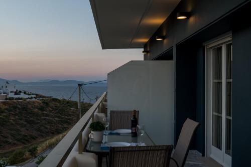 a balcony with a table and a view of the ocean at CHROMA Lodge Rafina in Rafina