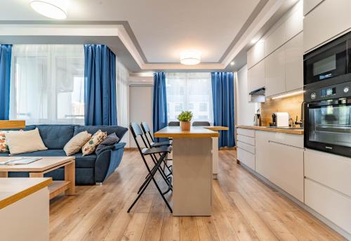 WrocApartments StarCenter في فروتسواف: مطبخ وغرفة معيشة مع أريكة وطاولة