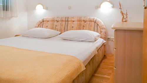 1 cama con cabecero de madera en una habitación en One bedroom apartment with terrace and seaview - B en Sevid