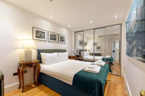 a bedroom with a large bed with a green blanket at Sherlocks in London