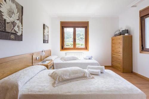 ein Schlafzimmer mit zwei Betten und einer Kommode in der Unterkunft GALIHOST - Casa Valboa in Meis