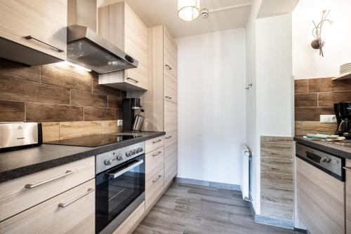 a kitchen with wooden cabinets and a stove at Das Filzmoos in Filzmoos