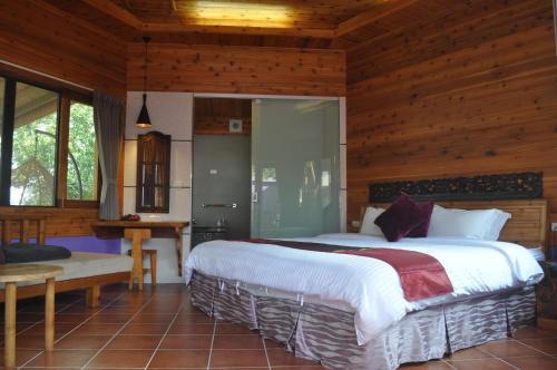 a bedroom with a large bed in a wooden room at Moon River Villa in Puli