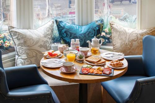 a table with breakfast food on it in front of a window at Sloane Square Hotel in London