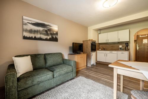 a living room with a couch and a kitchen at Das Filzmoos in Filzmoos