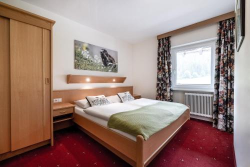 a bedroom with a bed and a window at Das Filzmoos in Filzmoos